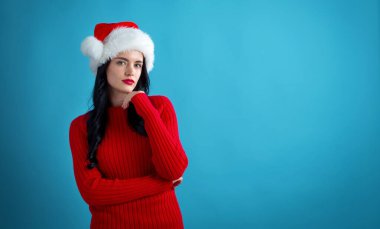 Noel Baba şapkalı genç bayan düşünceli.