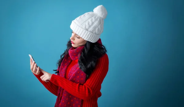 Молодая женщина с рождественской темой, используя свой телефон — стоковое фото