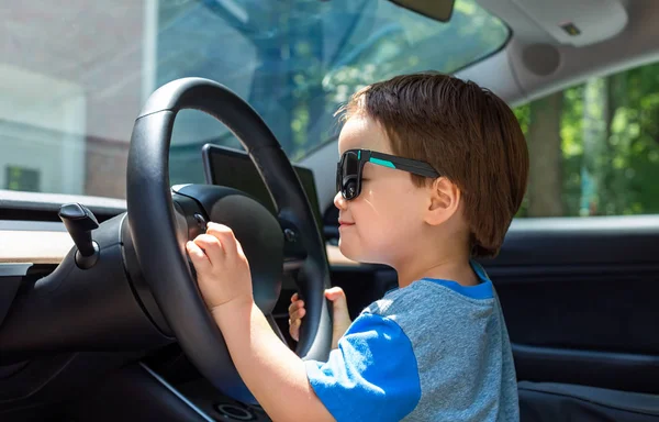 Egy kisgyerek, aki autóban játszik. — Stock Fotó