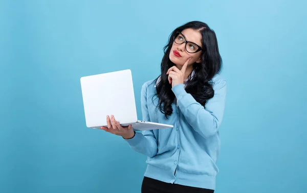 Mujer joven con un ordenador portátil en una pose reflexiva — Foto de Stock