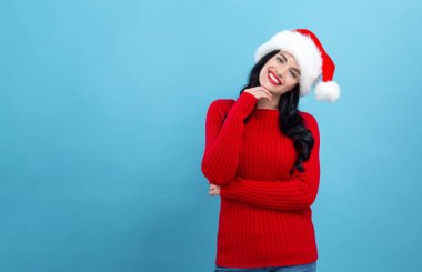 Noel Baba şapkalı genç bayan düşünceli.