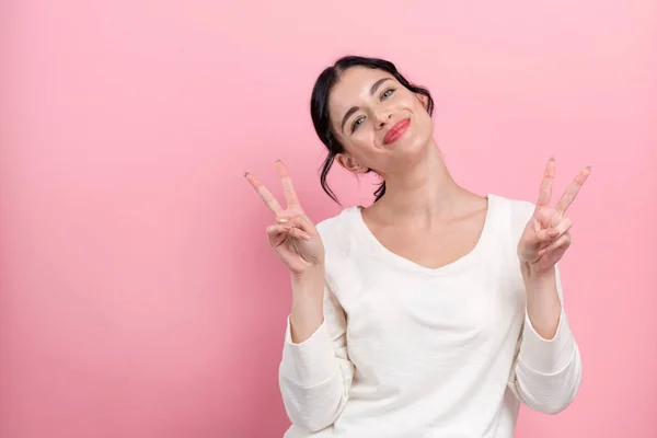 Junge Frau gibt das Friedenszeichen — Stockfoto