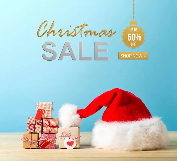 Christmas sale message with a Santa hat and gift boxes — Stock Photo, Image