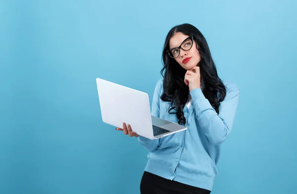 Mulher nova com um computador portátil em uma pose pensativa — Fotografia de Stock