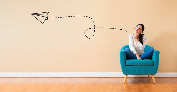 Paper airplane with woman in a thoughtful pose — Stock Photo, Image