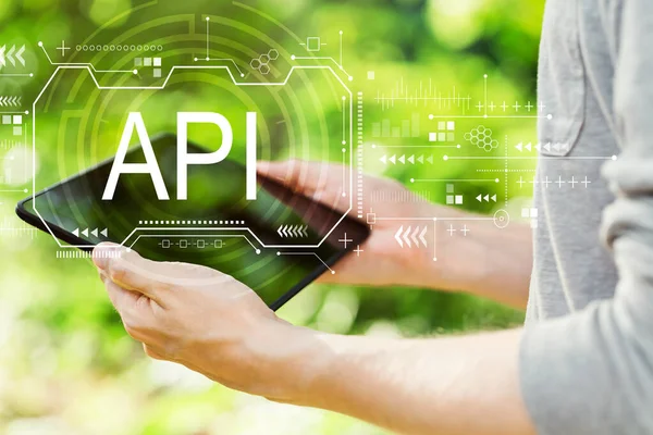 API concept with man holding his tablet — Stockfoto