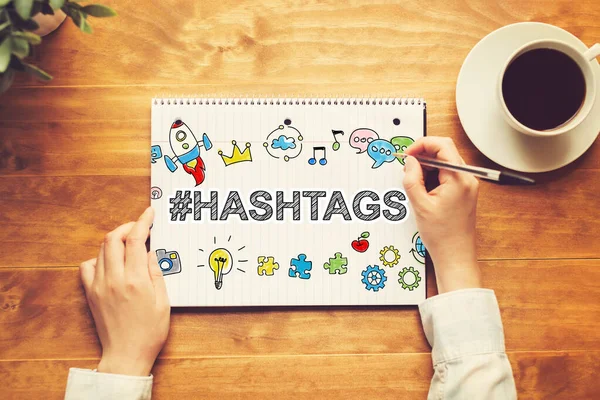 Hashtags texto com uma pessoa segurando uma caneta — Fotografia de Stock