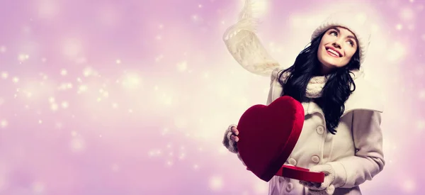 Young woman holding a big heart gift box — Stock Photo, Image