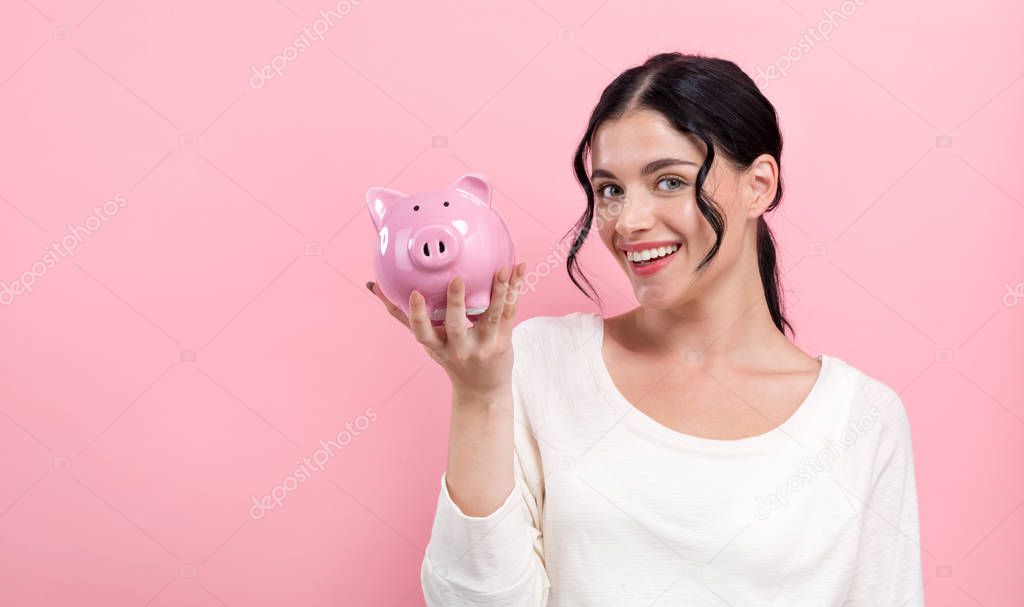 Young woman with a piggy bank