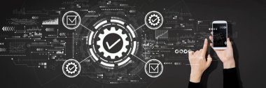 Akıllı telefon kullanan kişi ile kalite kontrol onayı