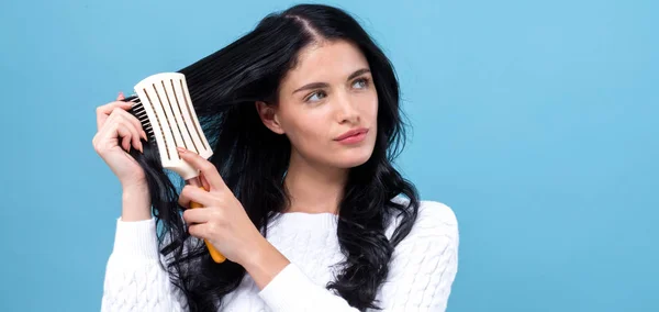 Красива молода жінка тримає щітку для волосся — стокове фото