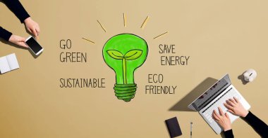 Green light bulb with people working together