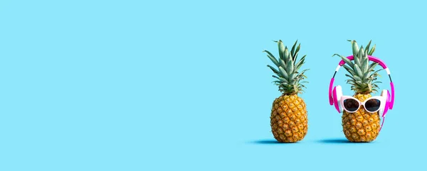 Pineapple wearing headphones with regular pineapple — ストック写真