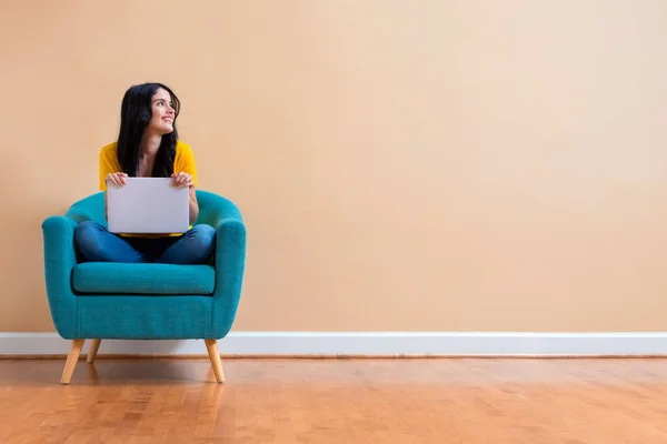 Giovane donna con un computer portatile in una posa premurosa — Foto Stock