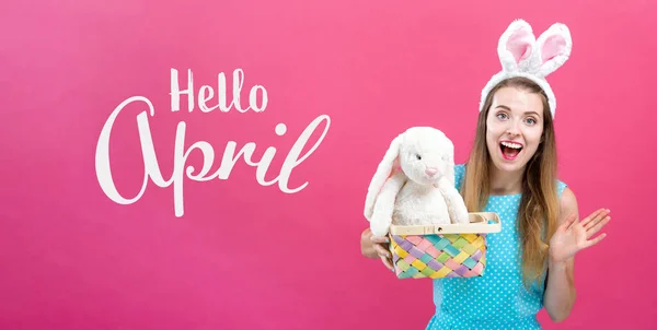 Hola mensaje de abril con mujer con cesta de Pascua —  Fotos de Stock