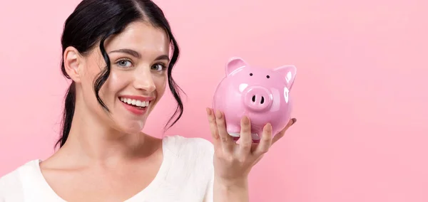 Junge Frau mit Sparschwein — Stockfoto