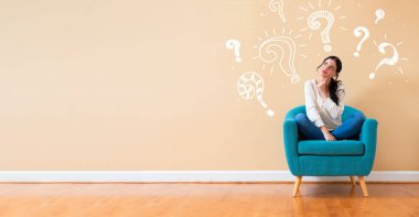 Question marks with woman in a thoughtful pose