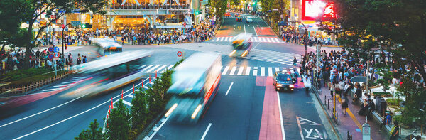 Люди пересекают знаменитый перекрёсток в Сибуе, Токио, Япония
