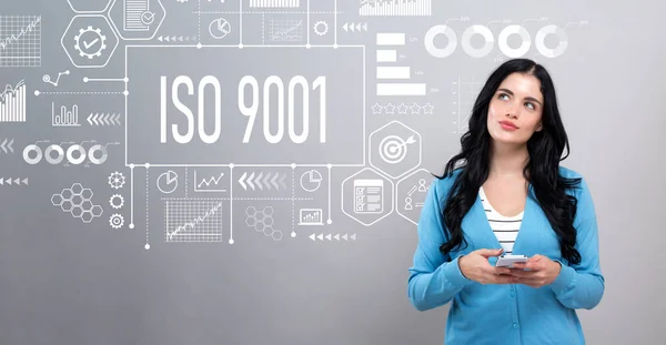 Iso 9001 koncept med kvinna som håller i en smartphone — Stockfoto