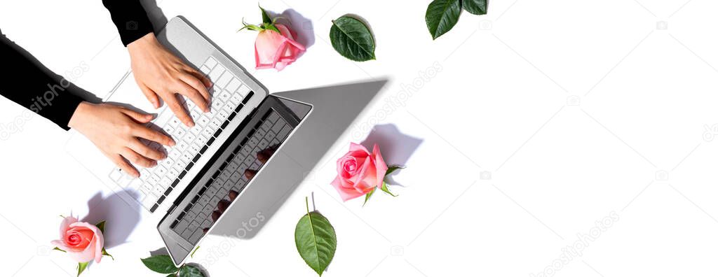 Woman using her laptop with pink roses