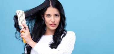 Bir saç fırçası tutan güzel genç kadın