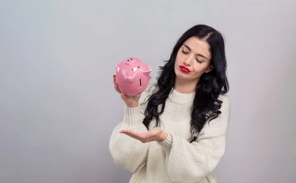 Young woman with a piggy bank — Stock Photo, Image