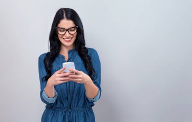 Genç bayan telefonunu kullanıyor.