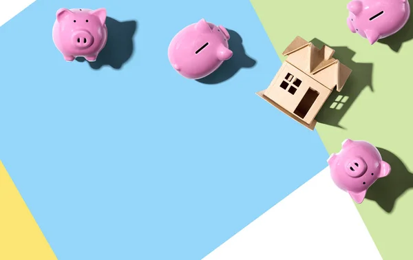 Casa em miniatura com bancos porquinhos — Fotografia de Stock