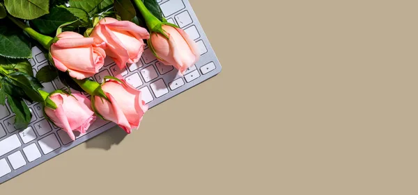Datortangentbord med rosa rosor — Stockfoto