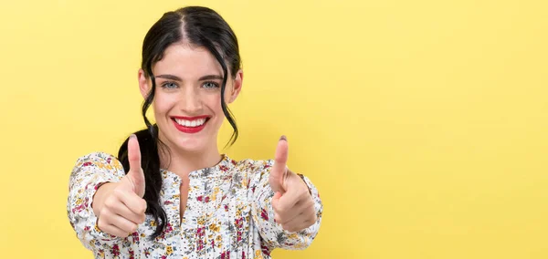 Young woman giving thumbs up — Stock Photo, Image