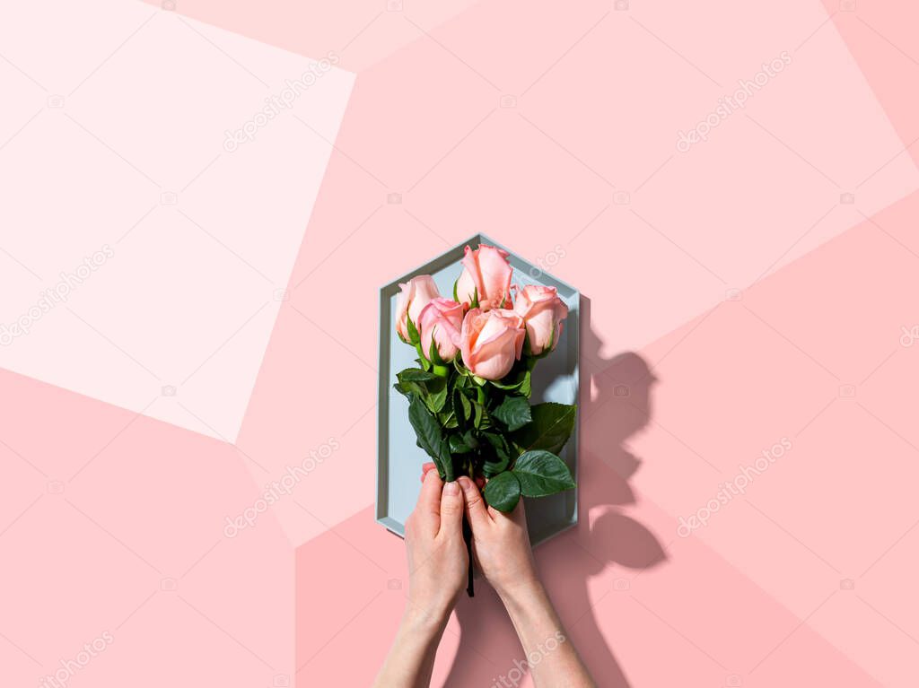 Woman holding pink roses overhead view