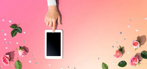 Mujer usando su tableta con rosas rosadas —  Fotos de Stock