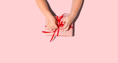 Küçük çocuk yukarıdan bir hediye kutusu yapıyor.