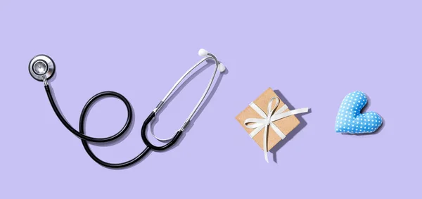 Stéthoscope avec un cadeau et un coussin cardiaque — Photo