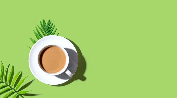 Eine Tasse Kaffee mit tropischen Blättern — Stockfoto