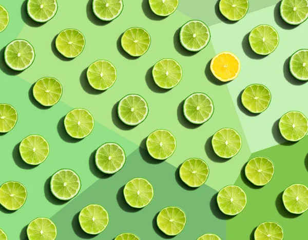 One out unique lemon surrounded by limes — Stock Fotó