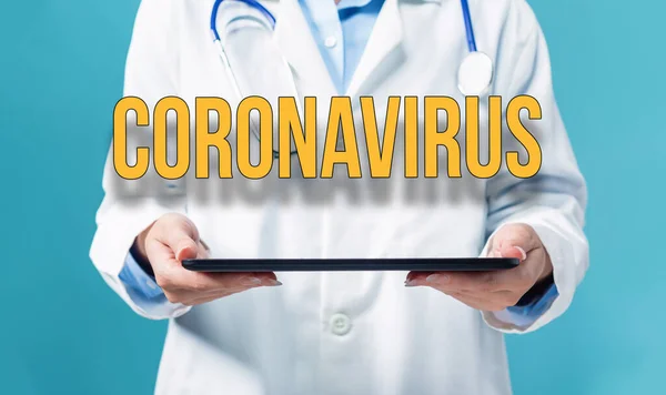 Coronavírus tema com um médico usando um tablet pc — Fotografia de Stock