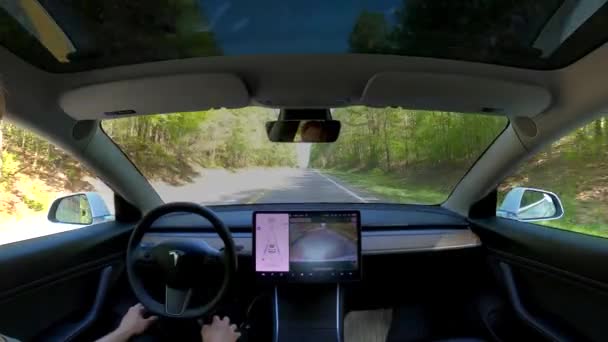 Pessoa dirigindo em piloto automático em um Tesla Modelo 3 — Vídeo de Stock