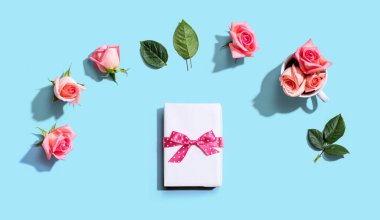 Üstünde pembe güller olan hediye kutusu.