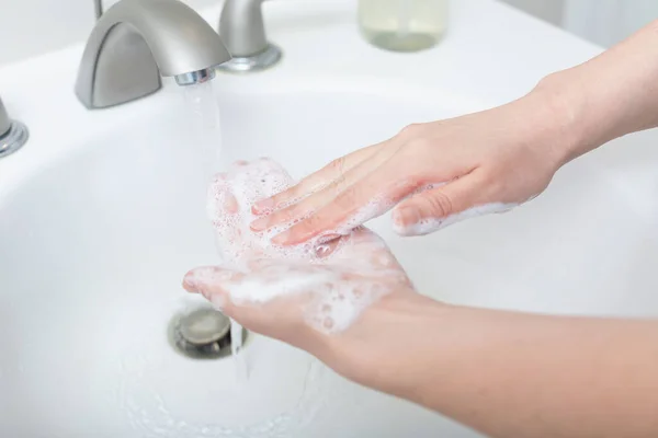 Person washing their hands at with soap and water — Stock Photo, Image