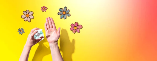 Applicazione di disinfettante per la pulizia delle mani con disegni floreali — Foto Stock