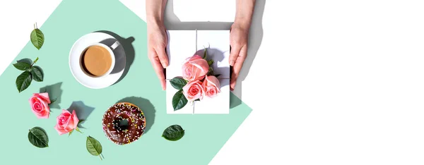 Mains féminines tenant un coffret cadeau avec des roses roses — Photo