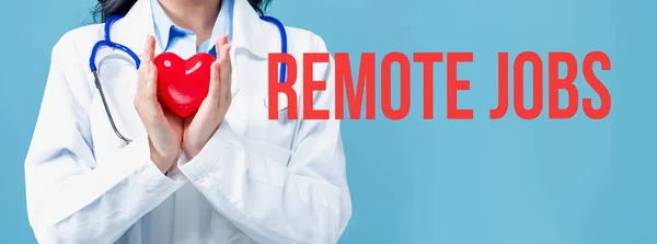 Remote Jobs tema med en läkare som håller ett hjärta — Stockfoto