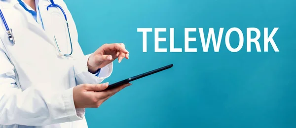 Tema do teletrabalho com um médico usando um tablet — Fotografia de Stock