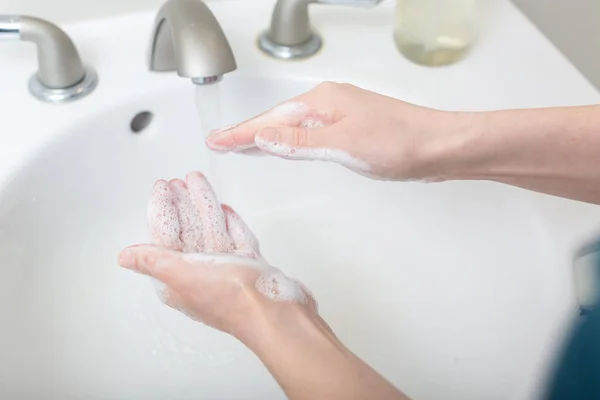 Person washing their hands at with soap and water — Stock Photo, Image