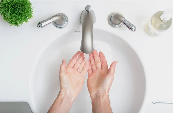 Persoon die zijn handen wast met water en zeep — Stockfoto