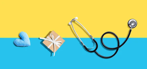 Stetoscopio con un regalo e un cuscino di cuore — Foto Stock