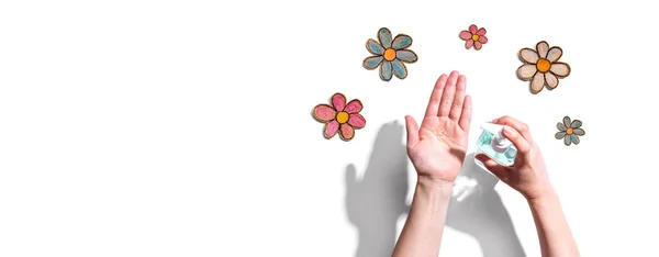 Aplicando desinfetante para limpar as mãos com desenhos de flores — Fotografia de Stock