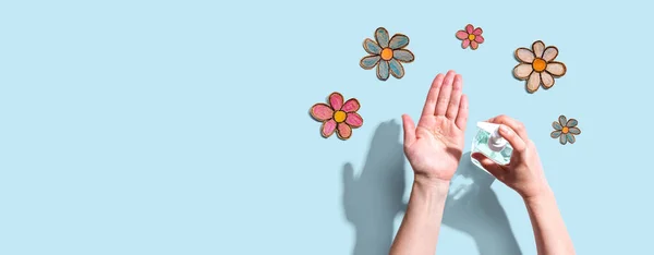 Aplicando desinfetante para limpar as mãos com desenhos de flores — Fotografia de Stock