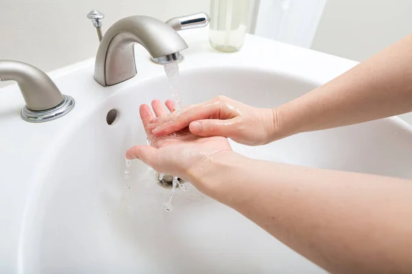 Person washing their hands at with soap and water — Stock Photo, Image